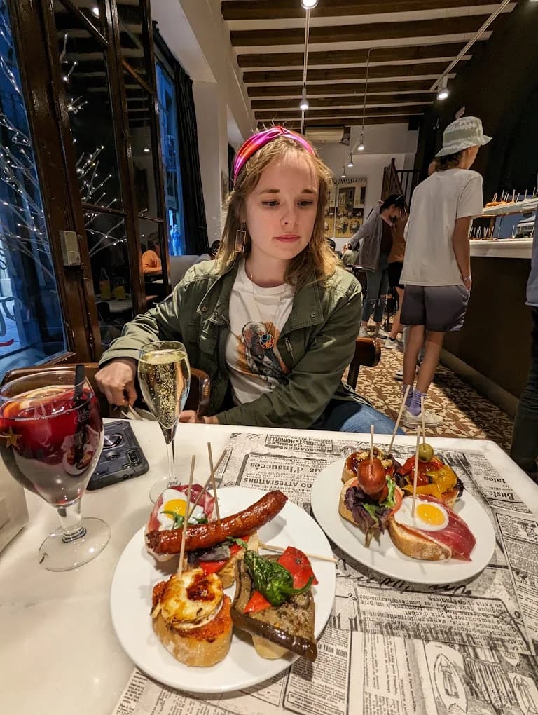 Una cliente che gusta un tavolo di tapas e cava