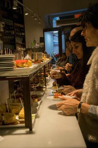 Clienti che scelgono le tapas al bancone di El Drac de Sant Jordi