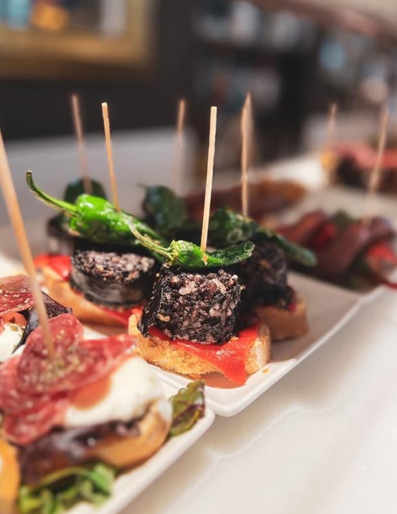 Camarero de El Drac de Sant Jordi sirviendo una bandeja de tapas